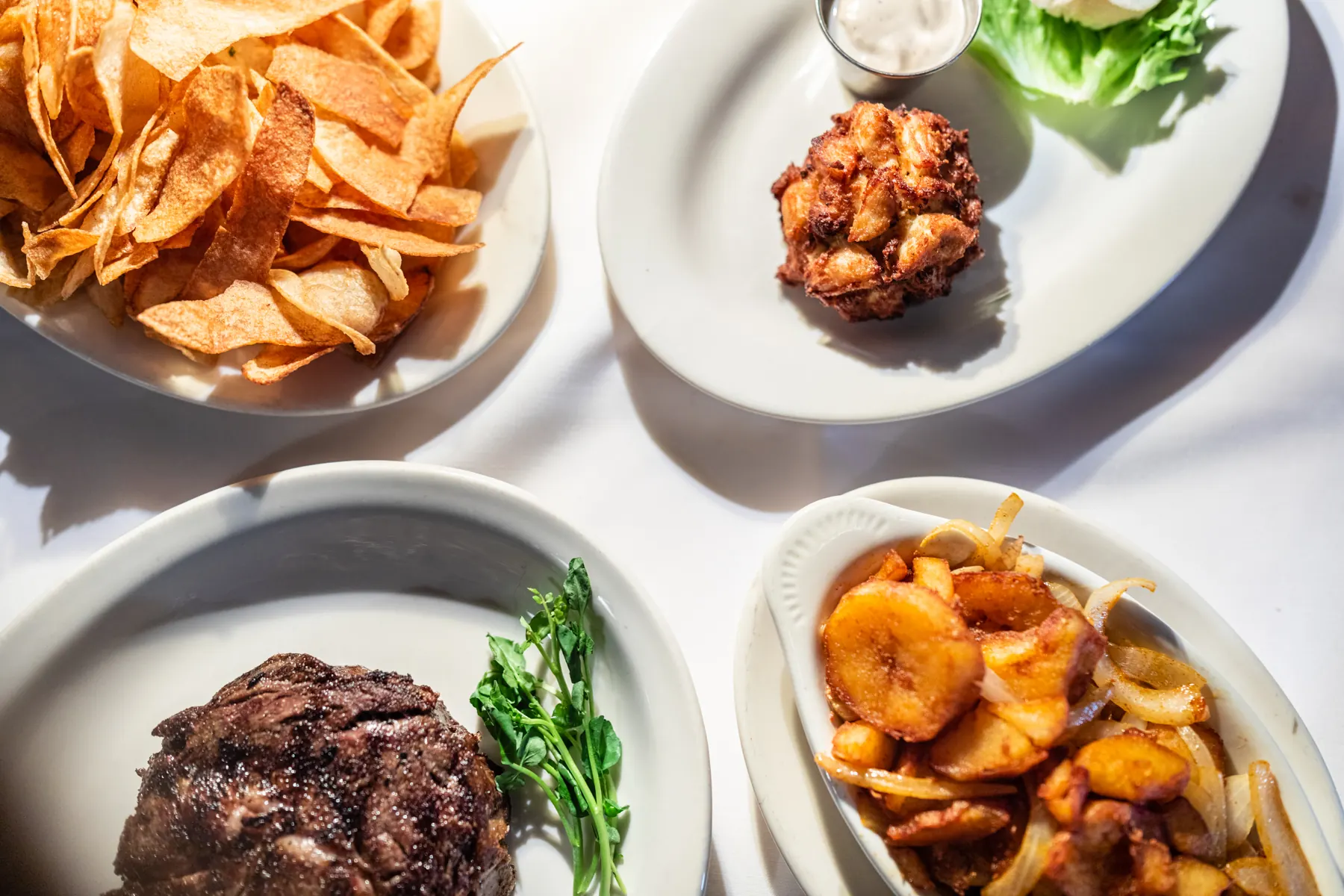 A signature spread of steak, crab cake, chips and cottage fries
